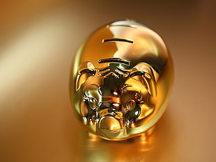 selective focus photography of gold-gold-colored coin bank