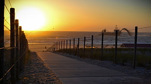 brown and black wooden bed frame, path, fence, sea, sunset