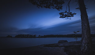 body of water under gray and black clouds during nighttime HD wallpaper