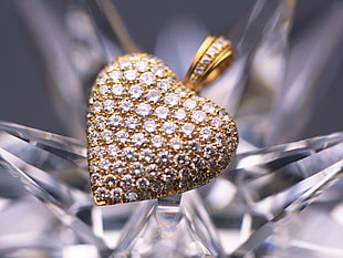 macro photography of gold with diamonds embellished heart-shaped pendant