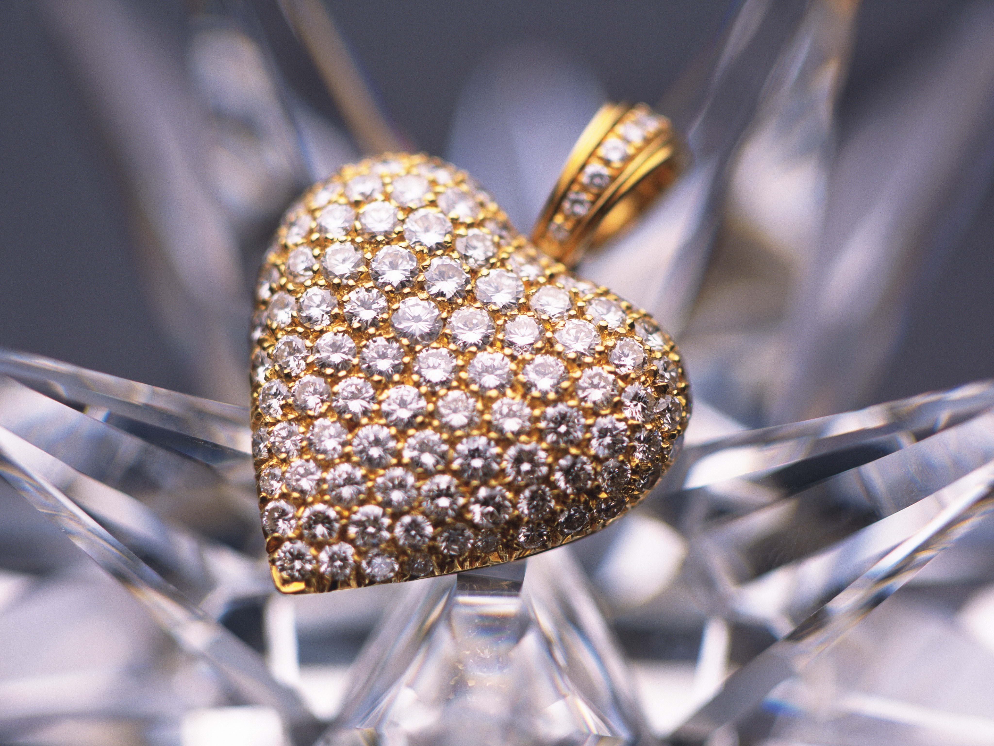 macro photography of gold with diamonds embellished heart-shaped pendant