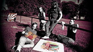 four men laying on red grass photo