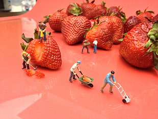 worker figurines near strawberries
