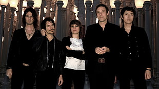group of people in black apparel standing next to lamp post backdrop