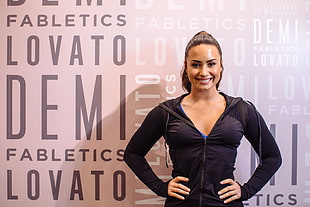 Demi Lovato standing near wall