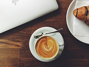 coffee latte on white ceramic mug and saucer