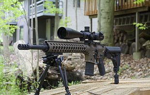 photograph of gray and black scoped rifle