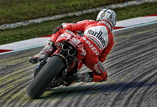 man riding a red Sports bike during daytime