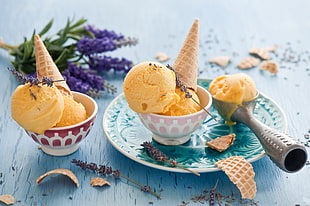 mango ice cream with ice cream cone on white ceramic bowl