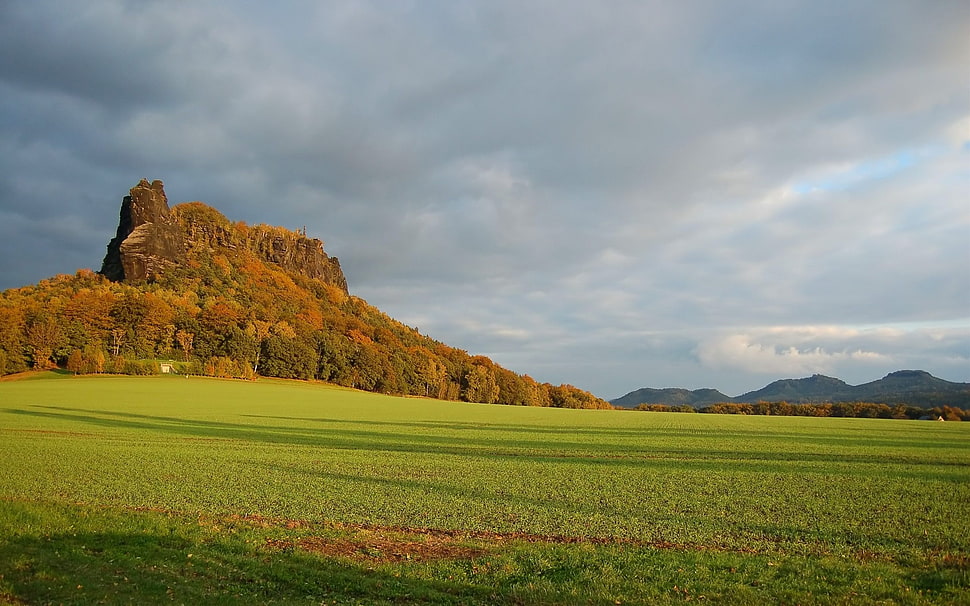 green mountain beside green grass field HD wallpaper