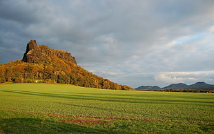 green mountain beside green grass field
