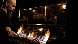 man playing a burning piano HD wallpaper