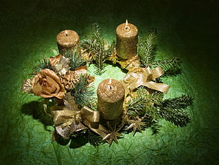 three brown pillar candle on top of garland