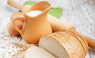close up photography of bread and brown ceramic mug with milk