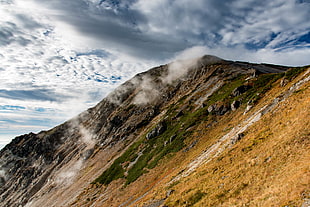 low angle photography of mountain under cumulus clouds