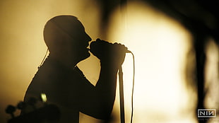 silhouette of man in front of microphone