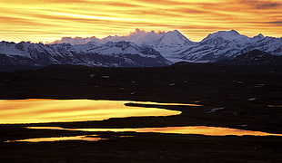 snow-covered mountain range during sunset photo