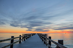 landscape photo of wooden dock with sunset as a background