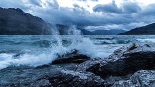 raging body of water on rocky cliffs HD wallpaper