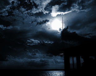 sea under moon on cloudy sky during night time HD wallpaper