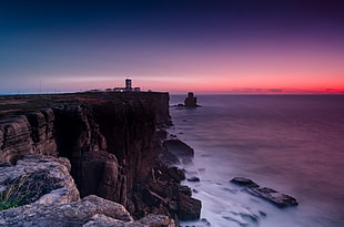 landscape photography of cliff beside ocean under sunset HD wallpaper
