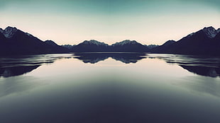landscape photography of reflection of mountains on body of water
