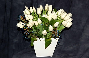 white tulip flowers with blue berries arrangement