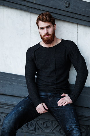 man wearing black long sleeved shirt and sitting on the bench