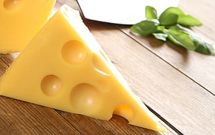 sliced cheese near green leaves