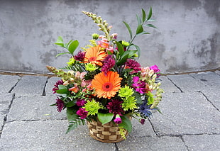 assorted flowers on brown wicker pot