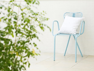 white throw pillow on gray chair near green plant