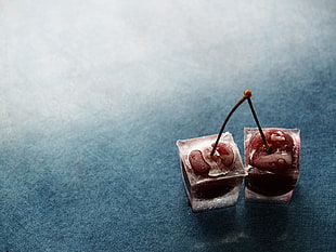 two square clear containers, blue, cherries (food), ice cubes