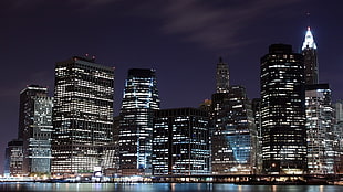 black and gray high-rise buildings during night time in landscape photograpgy