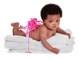 baby in white diaper lying on white textile