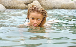blonde hair woman on body of water during daytime