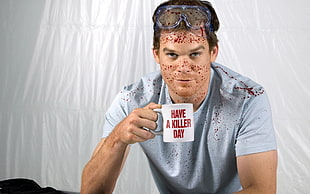 man wearing white shirt holding mug