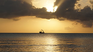 fish boat on body of water during sunset