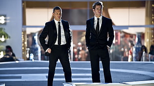 two man in black tuxedo coats standing outside building during night time