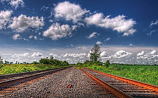 long exposure view of train rails under cumulus clouds