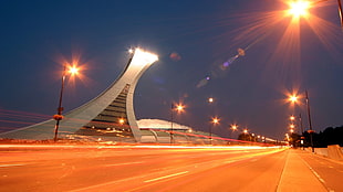 time lapse photography of road with gray tower building during nighttime