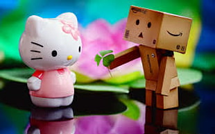 selective focus photography of box robot giving green leaf to Hello Kitty toys