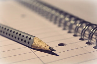 close up photography of pencil on notebook