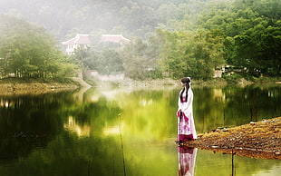 woman wearing purple and white kimono standing near green water