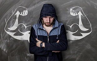 man in blue hoodie jacket with biceps of man's drawing behind him HD wallpaper