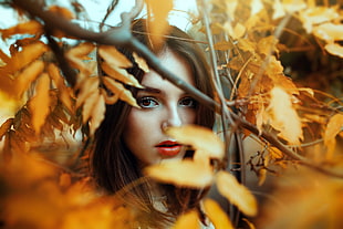 woman surrounded by brown leafed plants