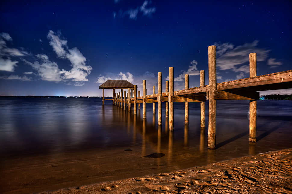 timelapse photo of dock near ocean under clouds during daytime HD wallpaper