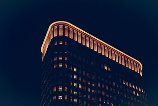 hi-rise building with orange lights during nightime HD wallpaper
