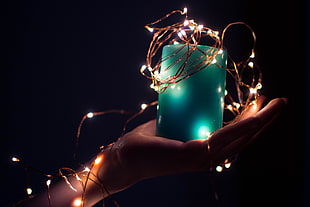 person hold blue candle with string lights