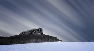 rock mountain near snow coated land HD wallpaper