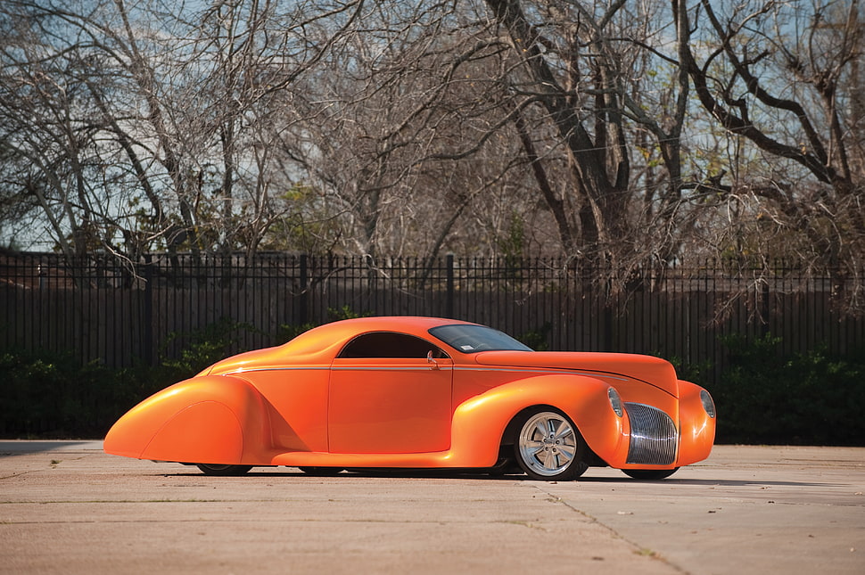 vintage orange coupe parked near fence and tree HD wallpaper
